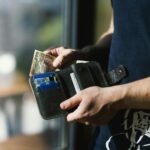 a person holding a wallet full of money